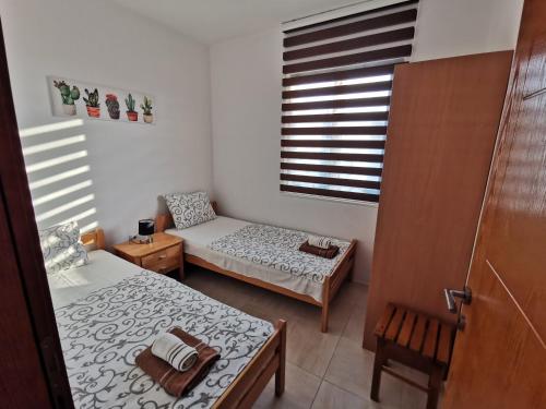 a small room with two beds and a window at Apartments Val Maslina in Utjeha