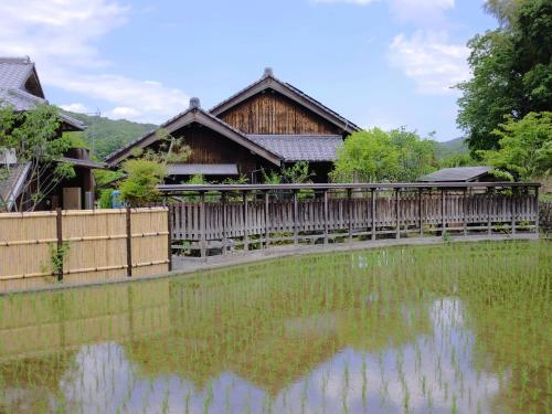 a house with a pond in front of it at まんのう清流庵 in Manno