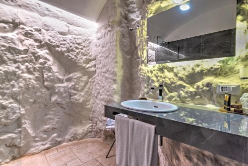 ein Badezimmer mit einem Waschbecken und einer Steinmauer in der Unterkunft Hotel Park Novecento Resort in Ostuni