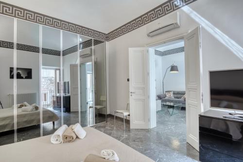 a bedroom with a bed and a tv and a living room at Villa Bordonaro - by Vacation Service in Cefalù