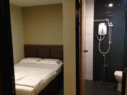 a bedroom with a bed and a shower and a toilet at B+ Hotel in Sungai Petani