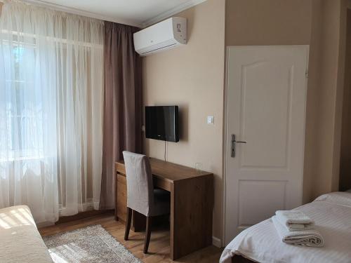 a bedroom with a television and a bed at Gościniec Kuklówka in Radziejowice