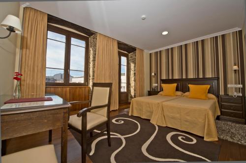 um quarto de hotel com uma cama e uma secretária em La Casona de Lazúrtegui em Ribadeo