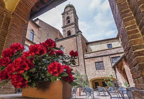 a church with a bunch of flowers in front of it at Il Chiostro Del Carmine in Siena