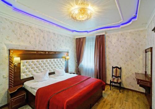 a bedroom with a large bed with a red blanket at VICTOR Hotel Resort & SPA in Truskavets