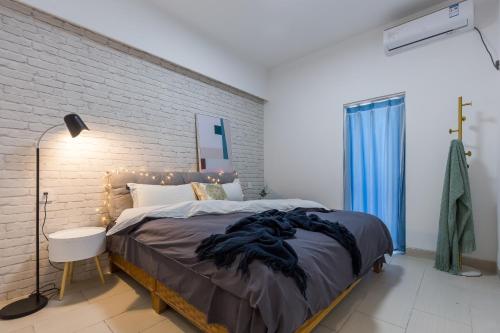 um quarto com uma cama grande e uma parede de tijolos em Sanya Sun Seaview Apartment em Sanya