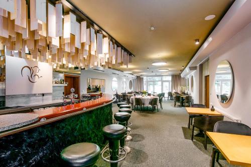 a restaurant with a bar with a row of stools at Hotel Veverica in Trenčín