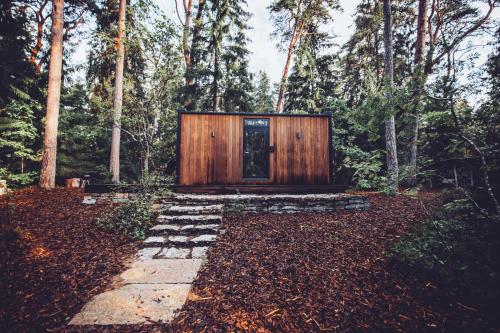 eine Hütte im Wald mit einer Tür in der Mitte in der Unterkunft ÖÖD Hötels Rannamõisa - with sauna in Rannamõisa