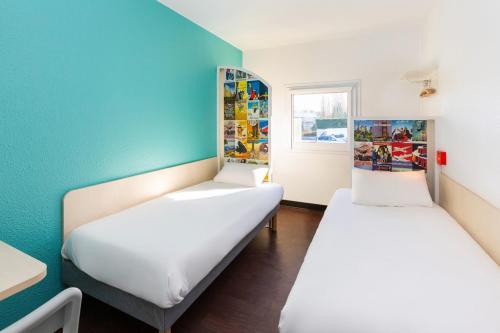 two beds in a room with blue walls at hotelF1 Avranches Baie Du Mont Saint Michel in Saint-Quentin-sur-le-Homme