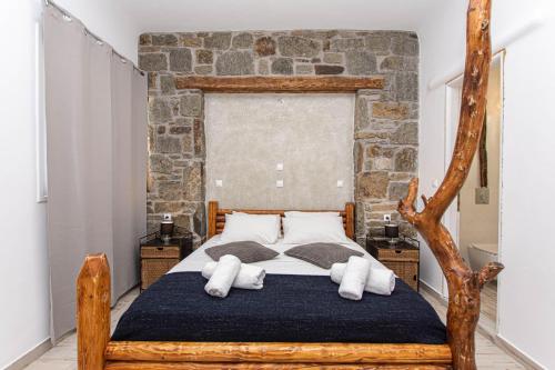a bedroom with a wooden bed with towels on it at Bebis House in Klouvas