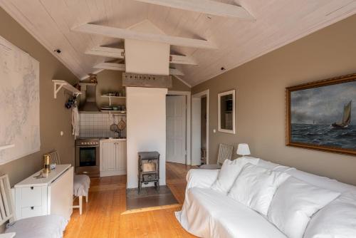 a living room with a white couch and a kitchen at Vaxholm Seaview Cottage in Vaxholm