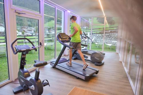 a man walking on a treadmill in a gym at Hotel Condor in San Vigilio Di Marebbe
