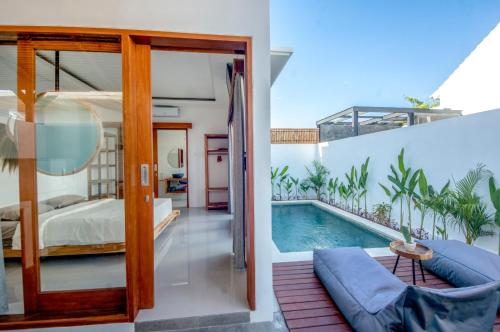 a bedroom with a bed and a swimming pool at Kiki Village Private Villas in Canggu