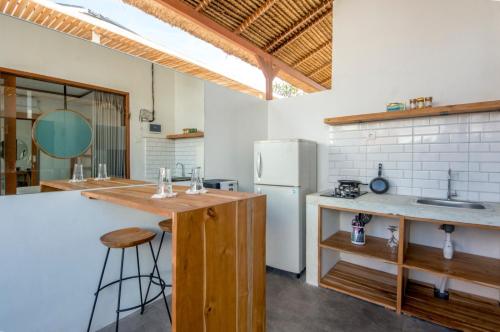a kitchen with a white refrigerator and a counter at Kiki Village Private Villas in Canggu