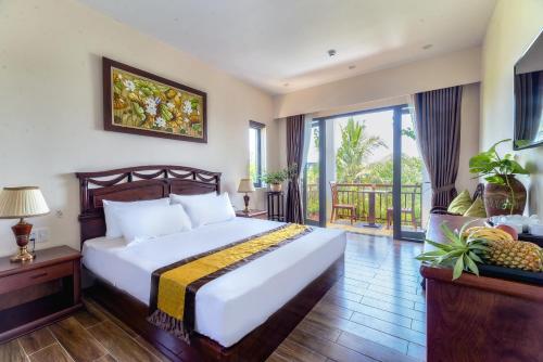 a bedroom with a large bed and a balcony at SHALA BOUTIQUE HOIAN in An Bang