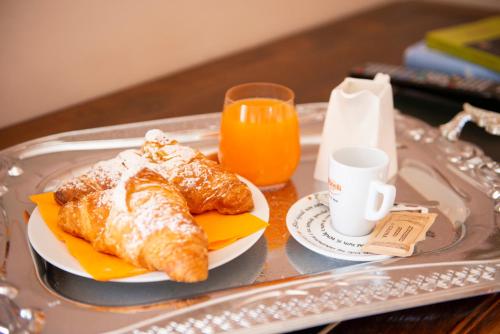 a tray with pastries and a cup of orange juice at Hotel Villa Quiete in Montecassiano