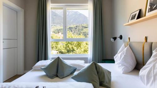 a bedroom with a bed with a large window at City Hotel Merano in Merano