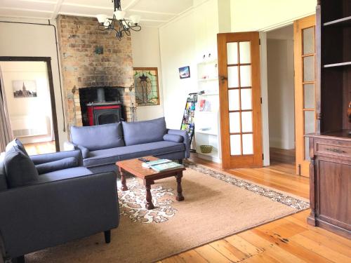 a living room with a blue couch and a table at Penmarric House - Self Check-in in Cambridge