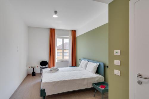 sypialnia z białym łóżkiem i oknem w obiekcie Camplus Guest Bernini Casa per Ferie w Turynie