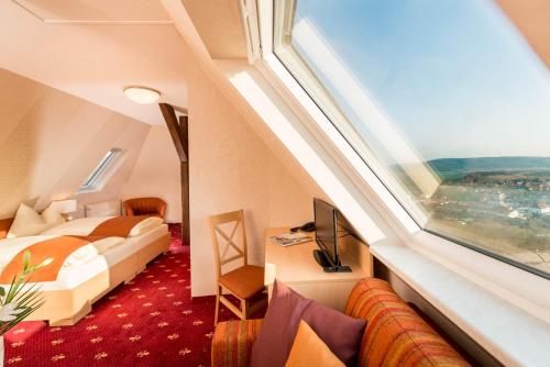 une chambre d'hôtel avec un lit et une fenêtre dans l'établissement Flair Hotel Villa Ilske, à Bad Kösen