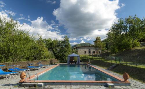 a swimming pool with chairs and a gazebo at Ursa Major Bubble in Camporgiano