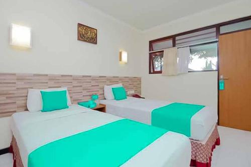 Ένα ή περισσότερα κρεβάτια σε δωμάτιο στο Hotel Lestari Near Lippo Plaza Mall Jember Mitra RedDoorz
