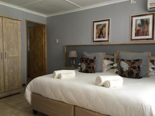 1 dormitorio con 1 cama grande y toallas. en African Dawn B&B en Calvinia