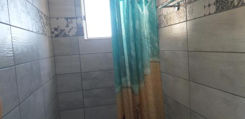 a shower with a blue shower curtain in a bathroom at Apostolakis Rooms in Agios Kirykos