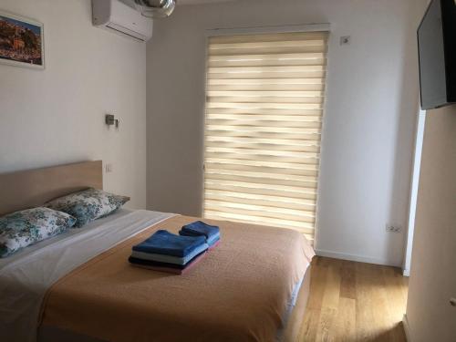 a bedroom with a bed with two towels on it at Apartments Bane in Herceg-Novi