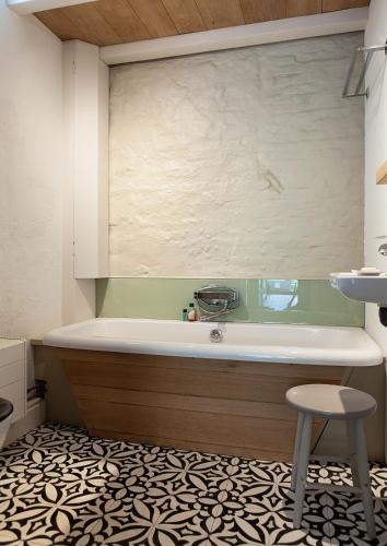 a bath tub in a bathroom with a stool at Family House Amsterdam in Amsterdam