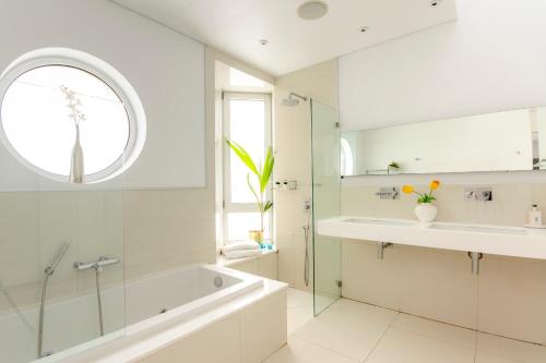a bathroom with a tub and a sink and a mirror at Katerina House in Perivolia