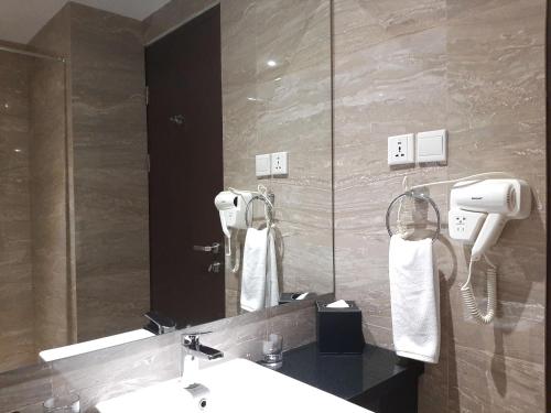 uma casa de banho com um lavatório e um espelho em ASTON Gorontalo Hotel & Villas em Gorontalo