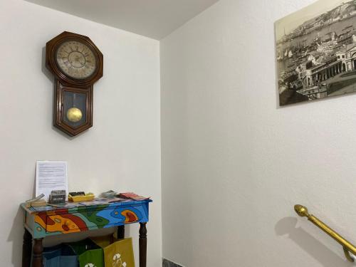 un orologio su un muro accanto a un tavolo di B&B DORMIRE DAI GRIMALDI a Genova