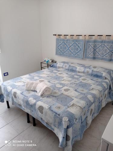 a bedroom with a bed with a blue and white quilt at I colori di Iglesias in Iglesias
