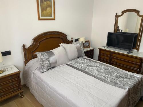 una camera con letto, TV e cassettiera di Chalet con piscina privada de 4 dormitorios Las Herrerias -cerca de Vera Playa- a Cuevas del Almanzora