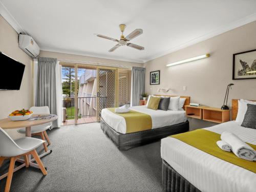 a hotel room with two beds and a balcony at Yamba Sun Motel in Yamba