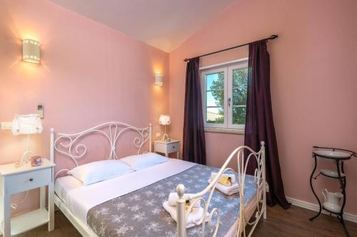 a bedroom with a white bed and a window at Villa Ari 8+2 in Krnica