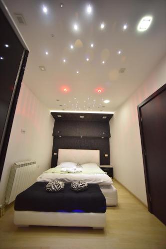 a bedroom with a bed with a black and white headboard at Apartman Grk 5 in Zlatibor