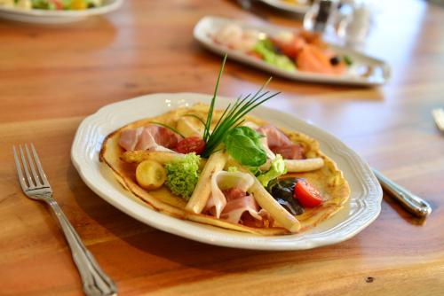 a plate of food on a wooden table at Lobinger Hotel Weisses Ross in Langenau