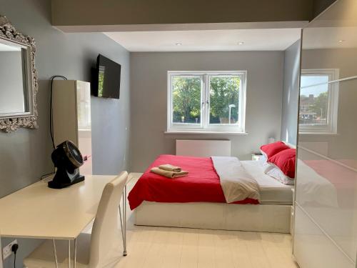 a bedroom with a red bed and a desk at Southernwood - Wantage Road House in Didcot
