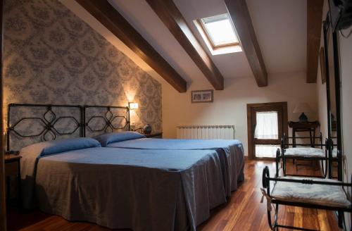 a bedroom with a large bed with a blue blanket at El Lagar del Vero in Huerta de Vero