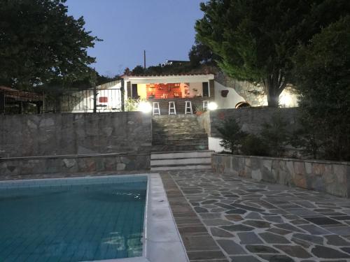 a house with a swimming pool at night at Villa Maroudia in Kymi