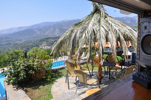 a patio with chairs and a table with a view at Villa Maroudia in Kymi