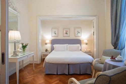 a hotel room with a bed and a chair at Serristori Palace Residence in Florence