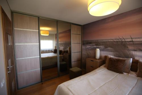 - une chambre avec un lit et une peinture murale dans l'établissement Park View Apartment, à Kaunas