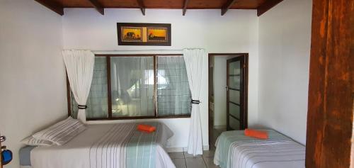 a bedroom with two beds and a window at 11 Manzini Chalets -Timone's Retreat in St Lucia