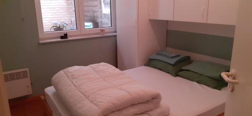 クノック・ヘイストにあるApp 2 slaapkamers Knokke-Heistのベッドと窓が備わる小さな客室です。