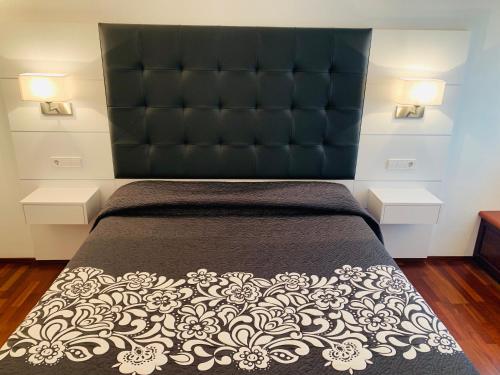 a bedroom with a large bed with a black headboard at Cala Tere 2on pis in Cadaqués