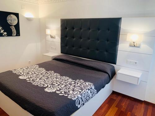 1 dormitorio con 1 cama grande y cabecero negro en Cala Tere 2on pis en Cadaqués