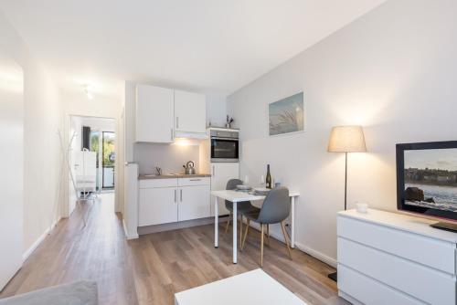 a living room with a table and a kitchen at Ferienapartments Neustadt in Holstein in Neustadt in Holstein